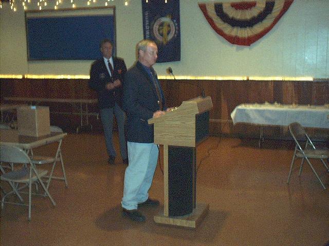 2006 Fall Conference - Estherville.        State Fire Marshal Jim Kenkel says a few words.  He was one of the 2006 Roger Mooty Award recipients.   President Claassen in background.  Ellen Hagen, Jewell also received an award.